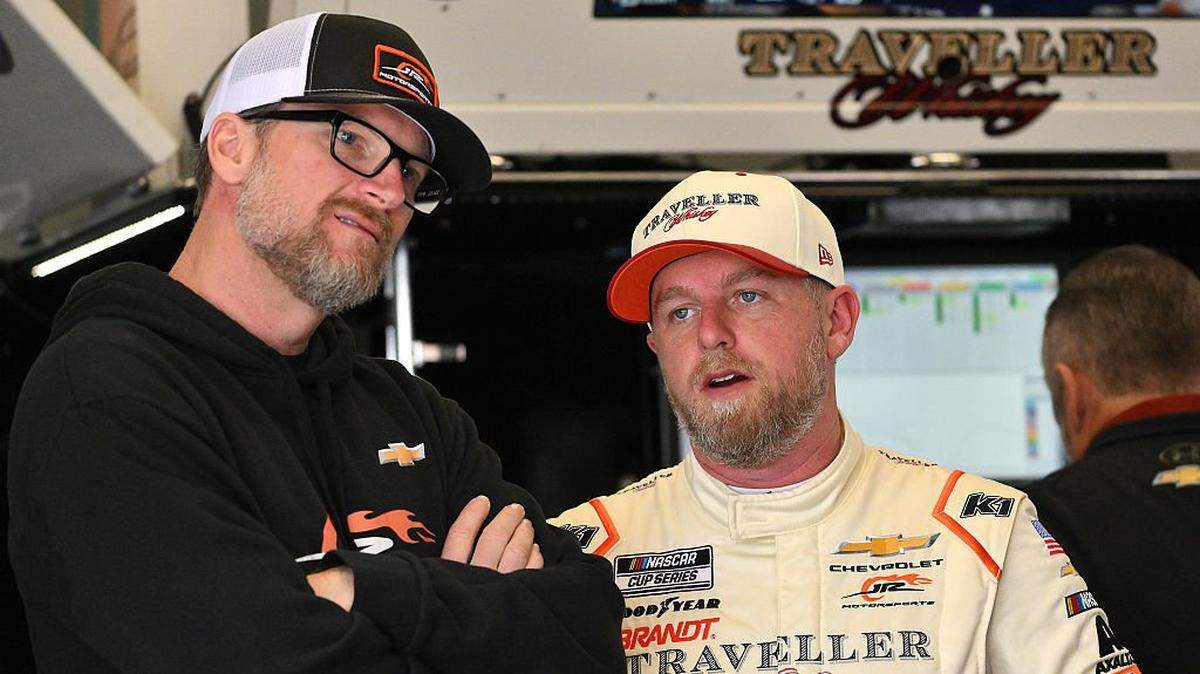 DAYTONA BEACH, FLORIDA - FEBRUARY 11: Dale Earnhardt Jr., owner of JR Motorsports, (L) and Justin Allgaier, driver of the #40 Traveller Whiskey Chevrolet, talk in the garage area during practice for the NASCAR Cup Series Daytona 500 at Daytona International Speedway on February 11, 2026 in Daytona Beach, Florida. (Photo by Jeff Curry/Getty Images)