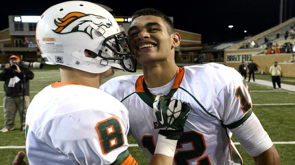 
(L-R) East Lincoln Mustangs wide receiver Nick Quigley (8) and quarterback Chazz Surratt (12) celebrate their 14-13 victory over the Washington Pam Pack during the NCHSAA 2AA State Championship game at BB&T Field at Wake Forest University in Winston-Salem, NC on Saturday, December 13, 2014. Surratt, a basketball and football star, was named NCHSAA male athlete of the year Thursday
