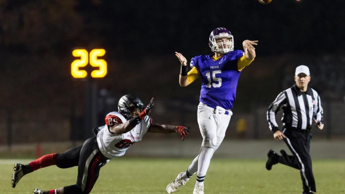 Northwestern quarterback #15 Gage Moloney avoids the defense to get off a pass as Northwestern dominates Westwood in 4A Division II playoff football. 11-27-2015