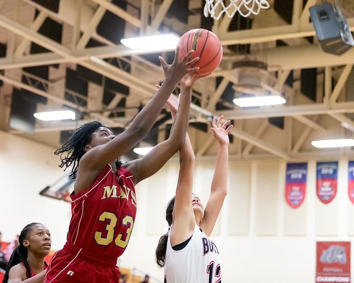 Mallard Creek’s Kennedy Alexander (33) goes over the Butler player for the rebound.