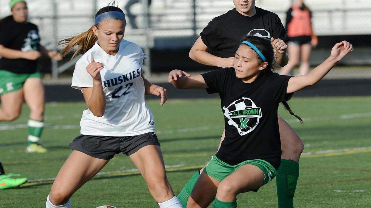 
Hough high's Ashley Johnson on left, pushes the ball away from A.L. Brown's Keri Xiong on right, during Tuesday's soccer match played at Hough High School April,28,2015. Hough defeated A.L. Brown 9-0.
