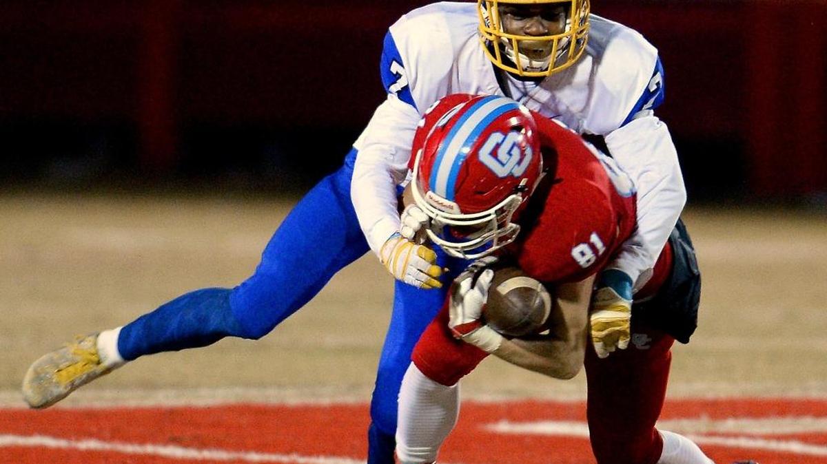 Charlotte Catholic wide receiver John Newman catches a pass under Dudley Panthers D.J. Crossen during Friday night’s game at Catholic.