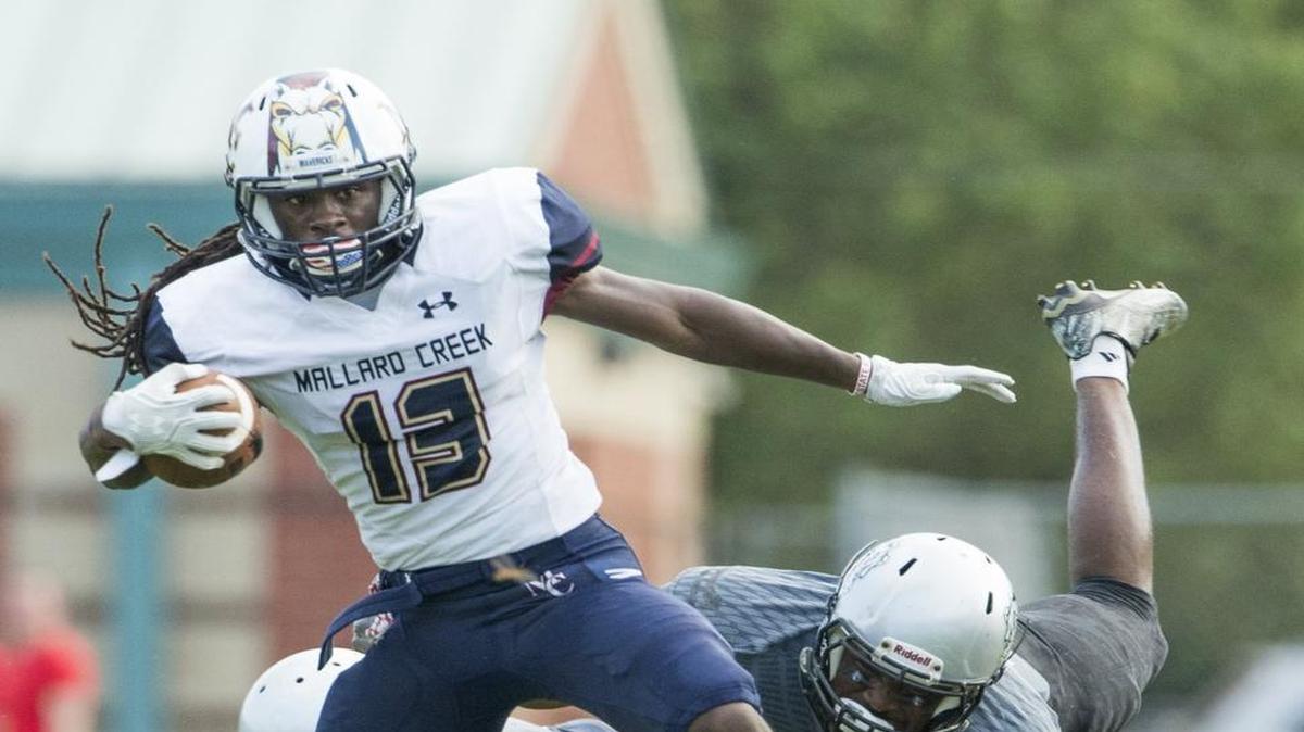 Mallard Creek ball carrier Jaques Taylor (13) tries to get past members of the Butler defense during a prep football game at Butler High School Friday, August 26, 2016 in Matthews, NC. Photo by JASON E. MICZEK - Special to the Observer