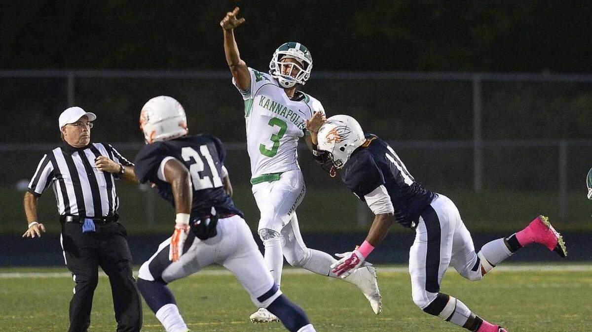 
A.L. Brown's quarterback Damon Johnson,center, passes the ball down field over two Vance tacklers during Monday night's football game played at Rocky River High School, Oct. 5, 2015. 
