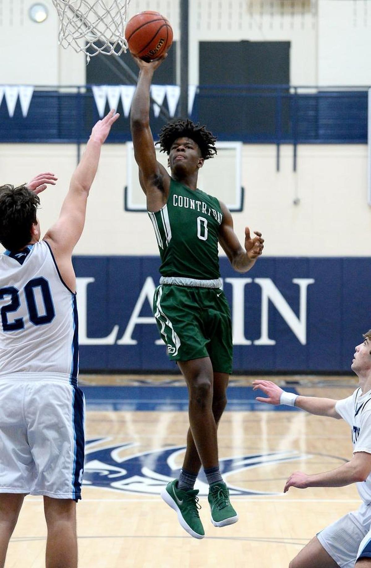 Charlotte Country Day School's DeAngelo Epps, right, releases a running one-handed shot over Charlotte Latin's Bennett Smith, left, during second half action on Monday, January 22, 2018 at Charlotte Latin School.