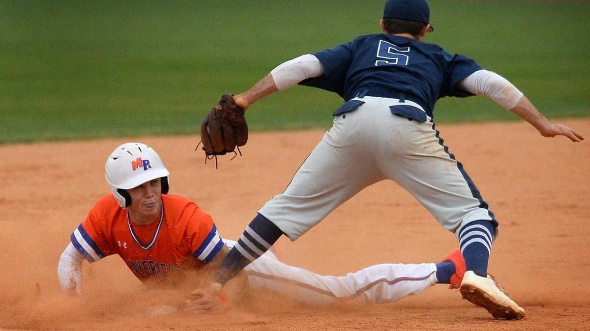 Marvin Ridge's Alex Leshock, left, slides safely into second base as East Rowan's Chandler blackwelder, right, looks for the ball during NCHSAA second round playoff action on Friday, May 12, 2017 at Marvin Ridge High School.