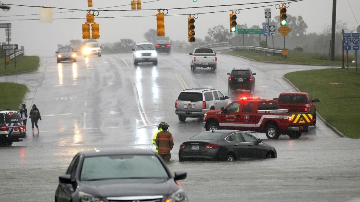 A motorist's car stalled out while trying to drive through the water as Main St. gets flooded over near the intersection with I-95 in Benson NC on Oct. 8, 2016. Hurricane Matthew brings heavy rains and flooding across the state NC on Oct. 8, 2016