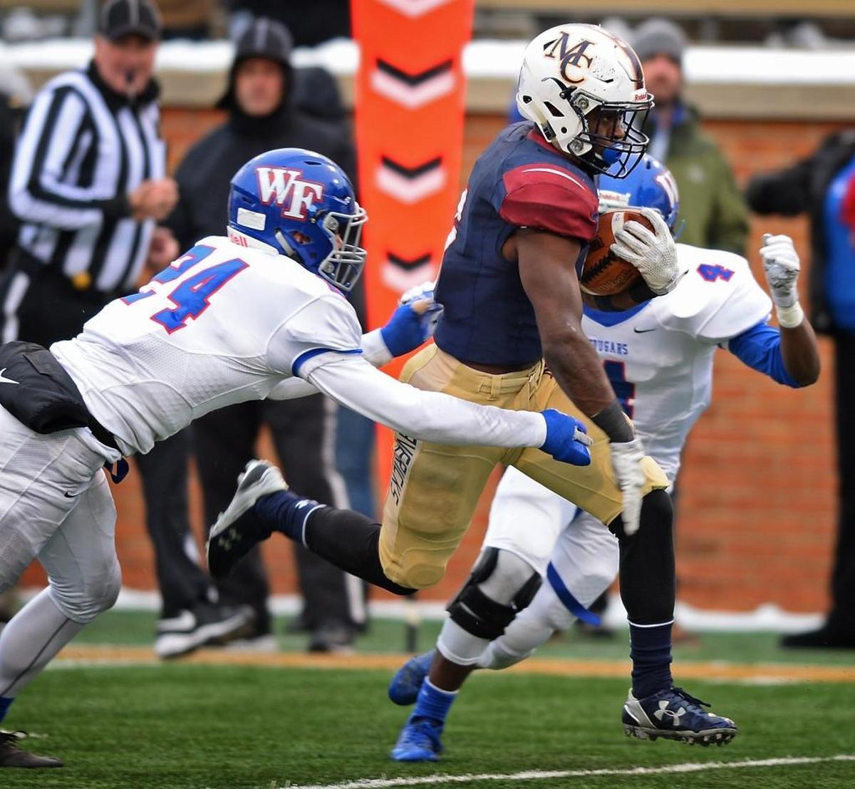 Wake Forest Cougars free safety Connor Loeffler, left and cornerback Eli Walker, right, try to tackle Mallard Creek running back Nasjzae Bryant in Saturday’s 4AA state championship game in Winston Salem. Wake Forest won 21-0.
