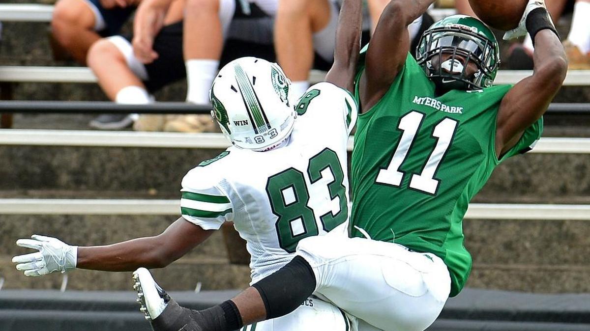 Myers Park’s Elijah Bowick, right, catches a touchdown pass from quarterback Jack Davidson as Charlotte Country Day’s Myles Browner defends Saturday night at Memorial Stadium. Myers Park won 34-7.