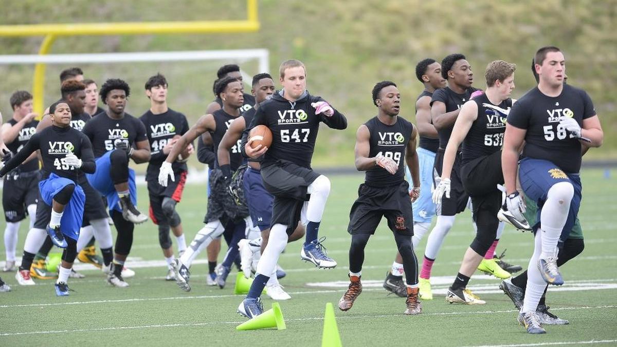 High school football players go through warm-up drills as they take part in Sunday’s VTO Sports Elite 100 Showcase camp.