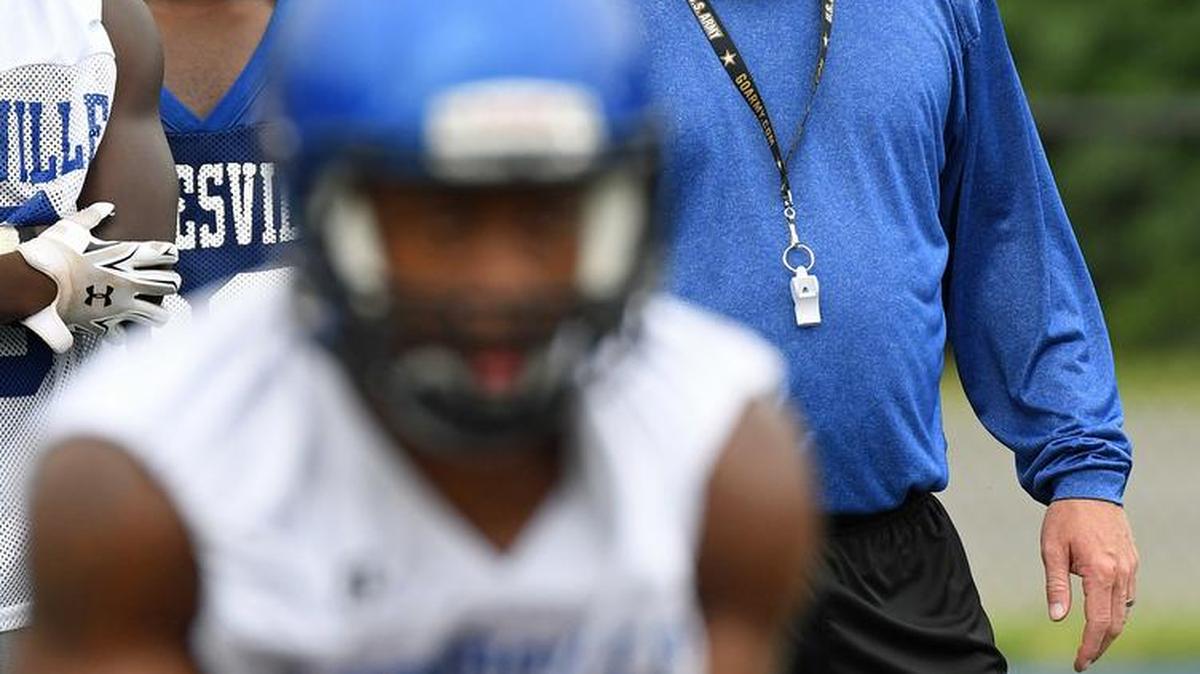 Mooresville High head football coach Marty Paxton looks on as the Blue Devils’ offense runs a play during the first day of summer practice, Aug. 1.