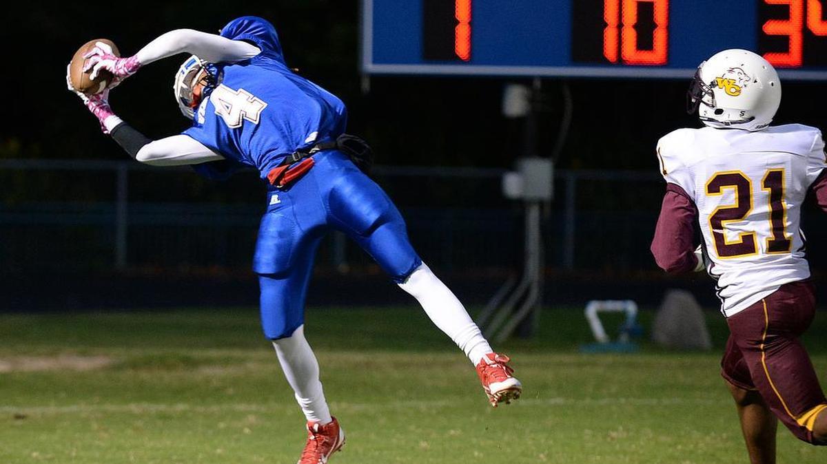 
North Meck wide receiver KJ Buford (4) stretches to catch the ball to score a touchdown as West Charlotte’s Jaylon Blakeney (21) approaches in Thursday’s game at North Meck.


