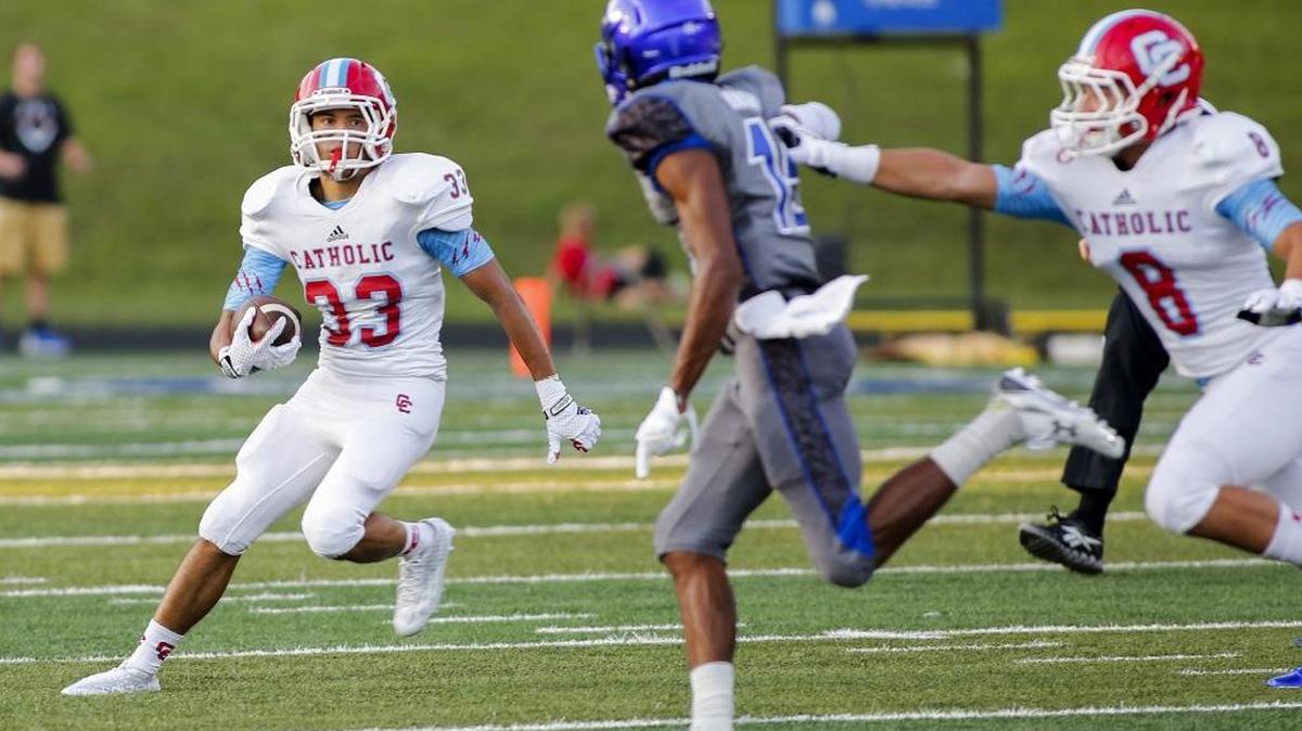 Charlotte Catholic running back Angel Marrero, left, finds running room against Charlotte Christian last August, when the teams met at Memorial Stadium. Catholic won 5-0.