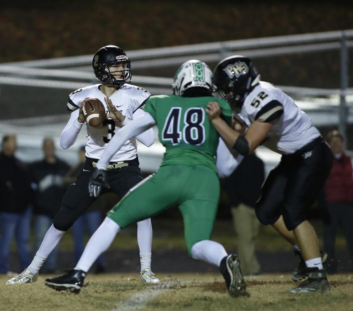 Providence quarterback Mason Boothe, left, looks for an open receiver as Myers Park tackle Jaden Craig (48) brings pressure during Friday’s N.C. 4AA playoff game. Myers Park won 55-7.
