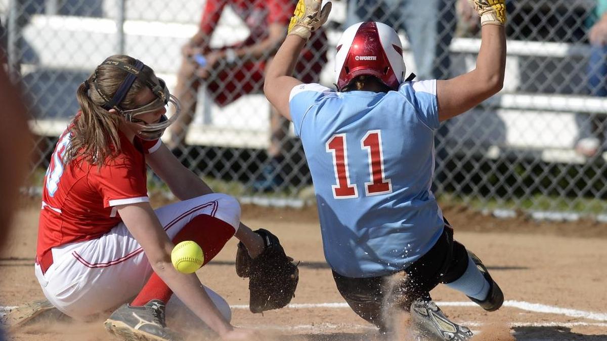 Olympic's Venus Gonzalez (11) slides safely home in front of Charlotte Catholic's Carrie Eberle (16) in the bottom of 13th inning for the winning run on April 22, 2013. The teams met to finish their March 26 game that was called at 12 inning due to darkness. Olympic won, 4-3, in the 13th inning.