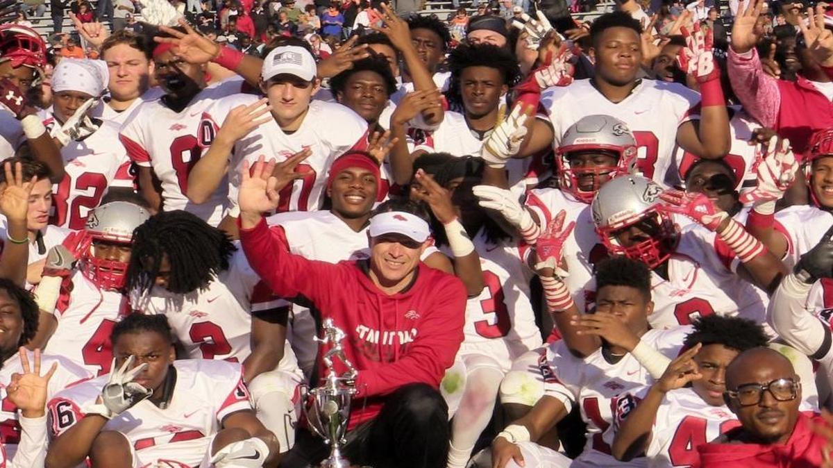 Rock Hill South Pointe head football coach Strait Herron, center, and his Stallions are a favorite to win a fourth straight state title. Above, the team poses after winning the 4A state championship title in December.