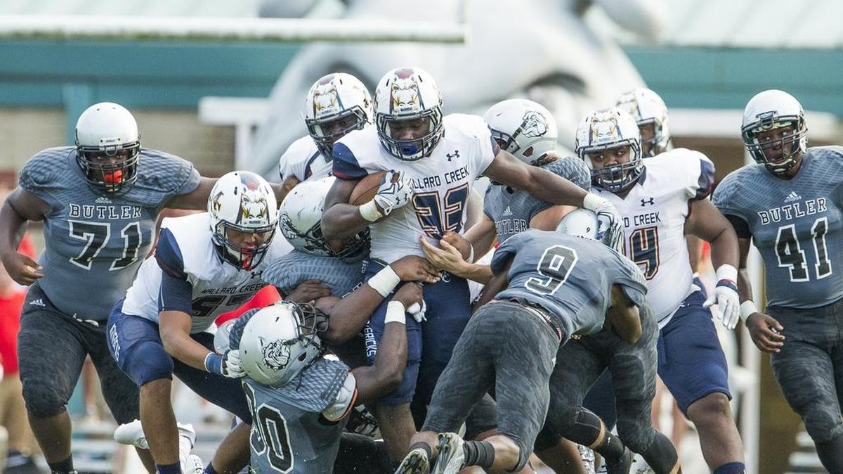 Mallard Creek’s Darnell Walker (33) tries to push past a host of Butler defenders during Friday’s game in Matthews. Mallard Creek won 35-20.