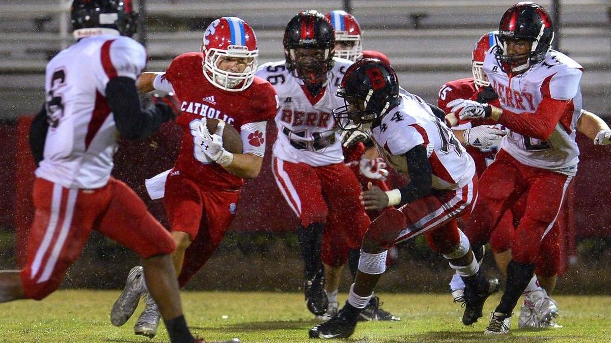 
Charlotte Catholic running back Jack Brigham, left, rushes for yardage as the Berry defense tries to make the tackle during first-quarter action on Friday at Charlotte Catholic.
