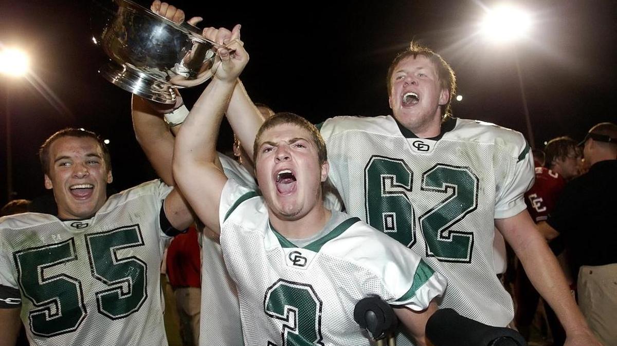 Charlotte Country Day players Hunter Fede (3) Max Gruder (55) and Will McGoogan (62) hold high the John R. Cook Cup after defeating Charlotte Catholic 13-11 in 2006, but the series has been lopsided of late -- to Catholic’s side. CHRIS KEANE - SPECIAL TO THE OBSERVER