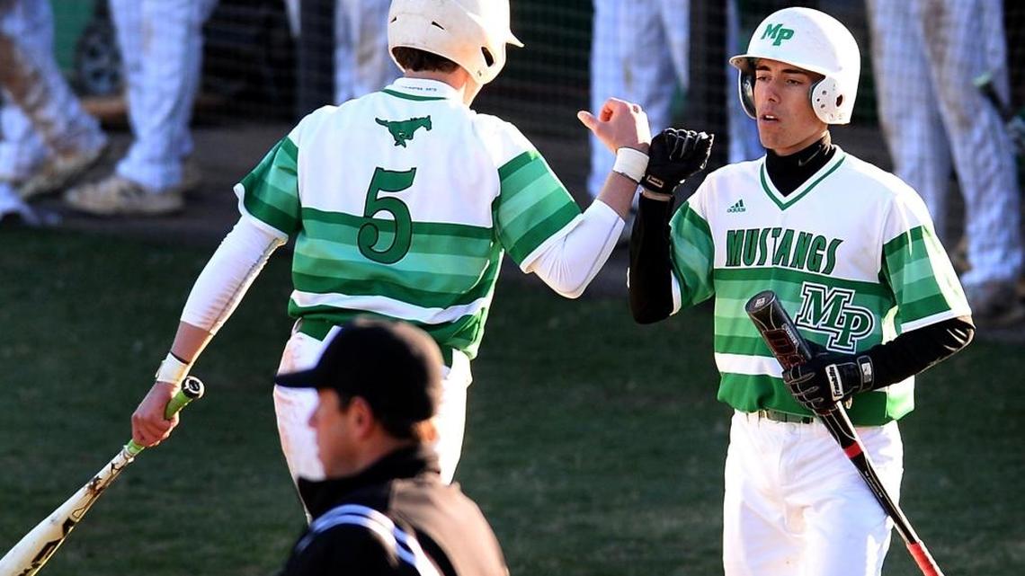 Myers Park Mustangs John Owens, left, is congratulated by teammate Bennett Dean, right, after Owens scored a run against Butler during prep baseball action against Myers Park on Wednesday, March 15, 2017 at Myers Park High School.