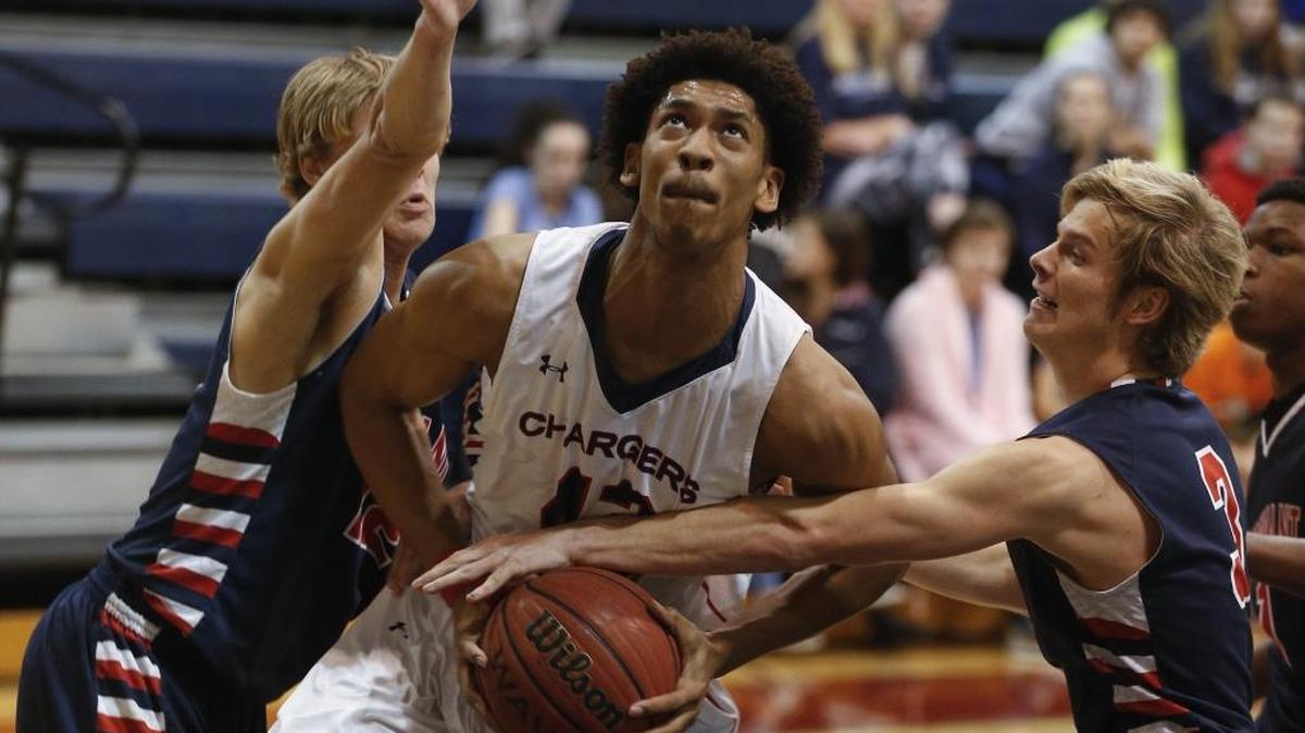 Providence Day forward Joshua Howard, center, drives to basket as Covenant Day forward Jake Glass tries to strip away the ball in the first half of a prep basketball game Monday, Jan. 25, 2016. (Nell Redmond photo)