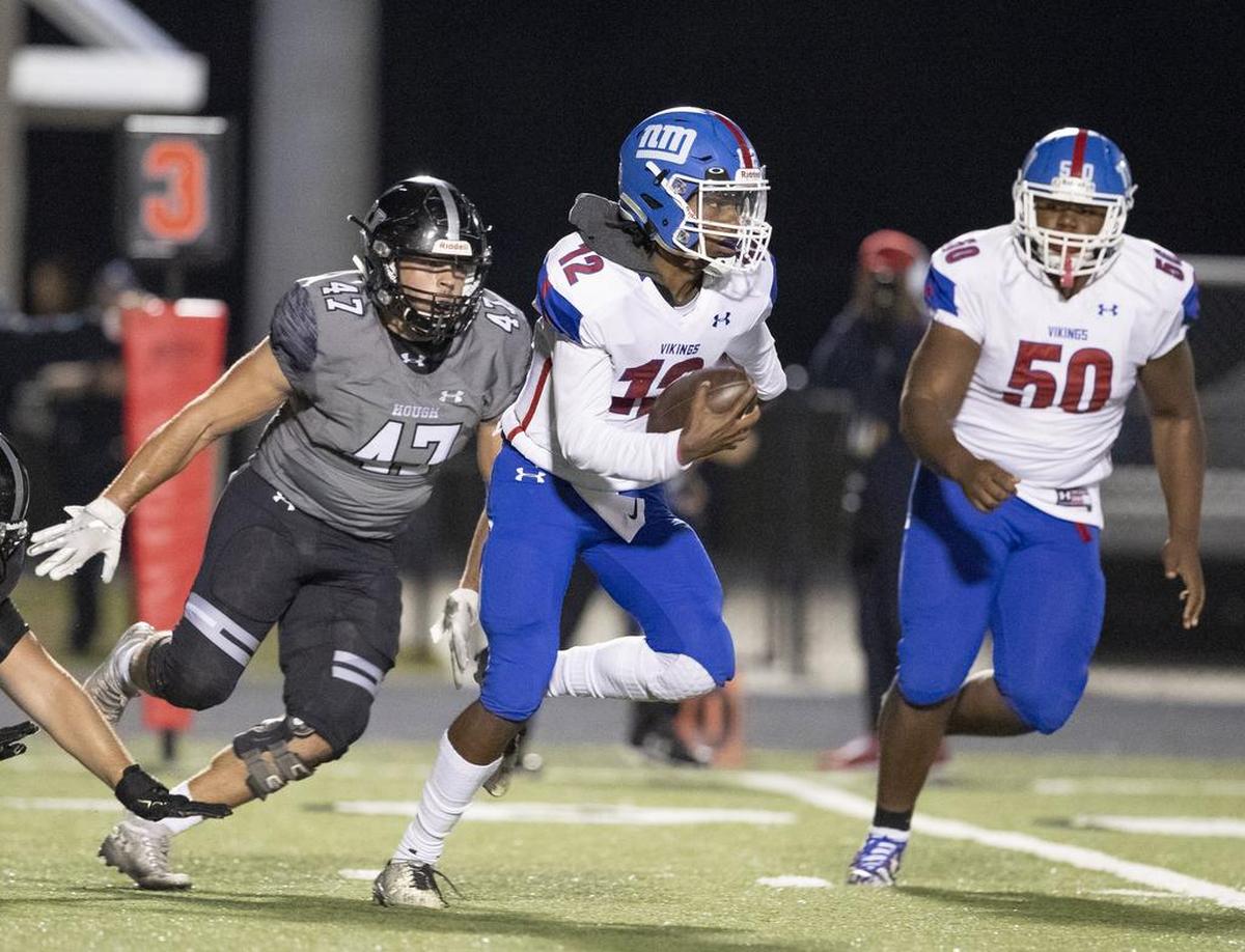 North Meck quarterback Aaron Scott keeps the ball on a running play against Hough.