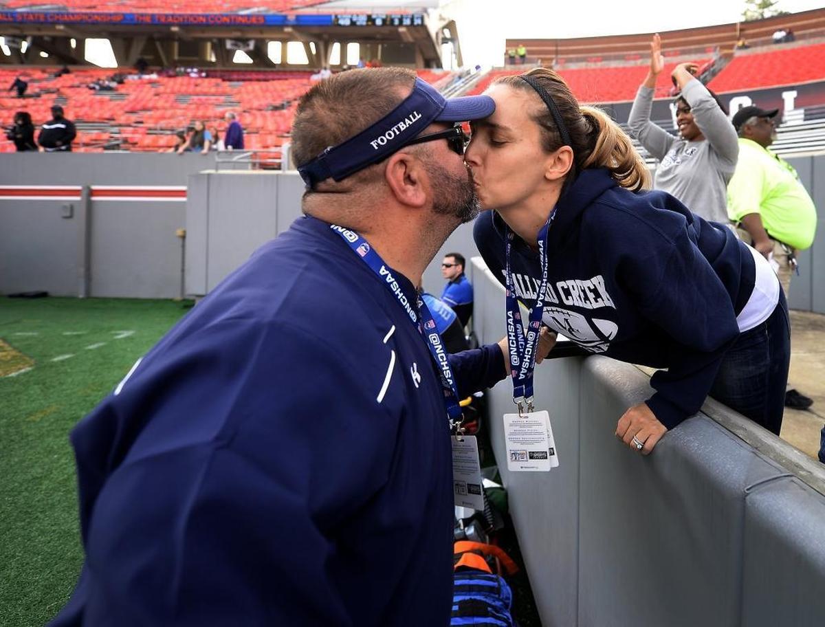 In 2015, Mallard Creek football coach Mike Palmieri received a congratulatory kiss from his wife, Katie, after the Mavericks beat Greensboro Page 49-6 to capture their third consecutive 4AA state championship. Palmieri was later named Associated Press N.C. Coach of the Year.