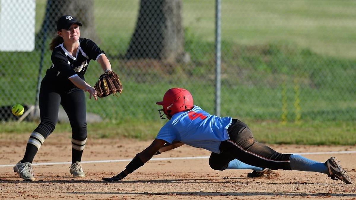 Olympic's Moriah Terry dives into third base safely during a rundown as Providence's Erin Gabriel, left, is unable to field the ball during prep softball action on Wednesday, April 26, 2017 at Olympic High School. Providence defeated Olympic 3-1.