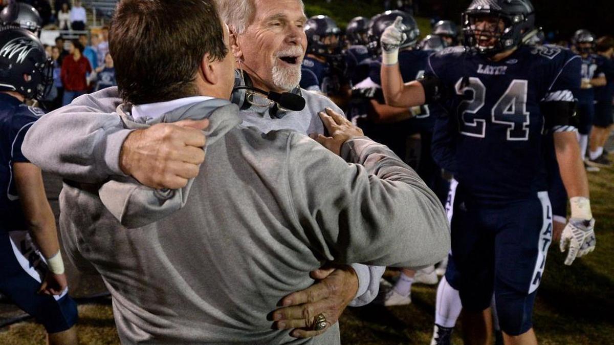 Charlotte Latin head coach Larry McNulty, facing camera, is embraced by an assistant coach as time expires in the team's game against Charlotte Christian in the NCISAA football championship game at Charlotte Latin School on Friday, November 11, 2016. Charlotte Latin defeated Charlotte Christian 28-27.