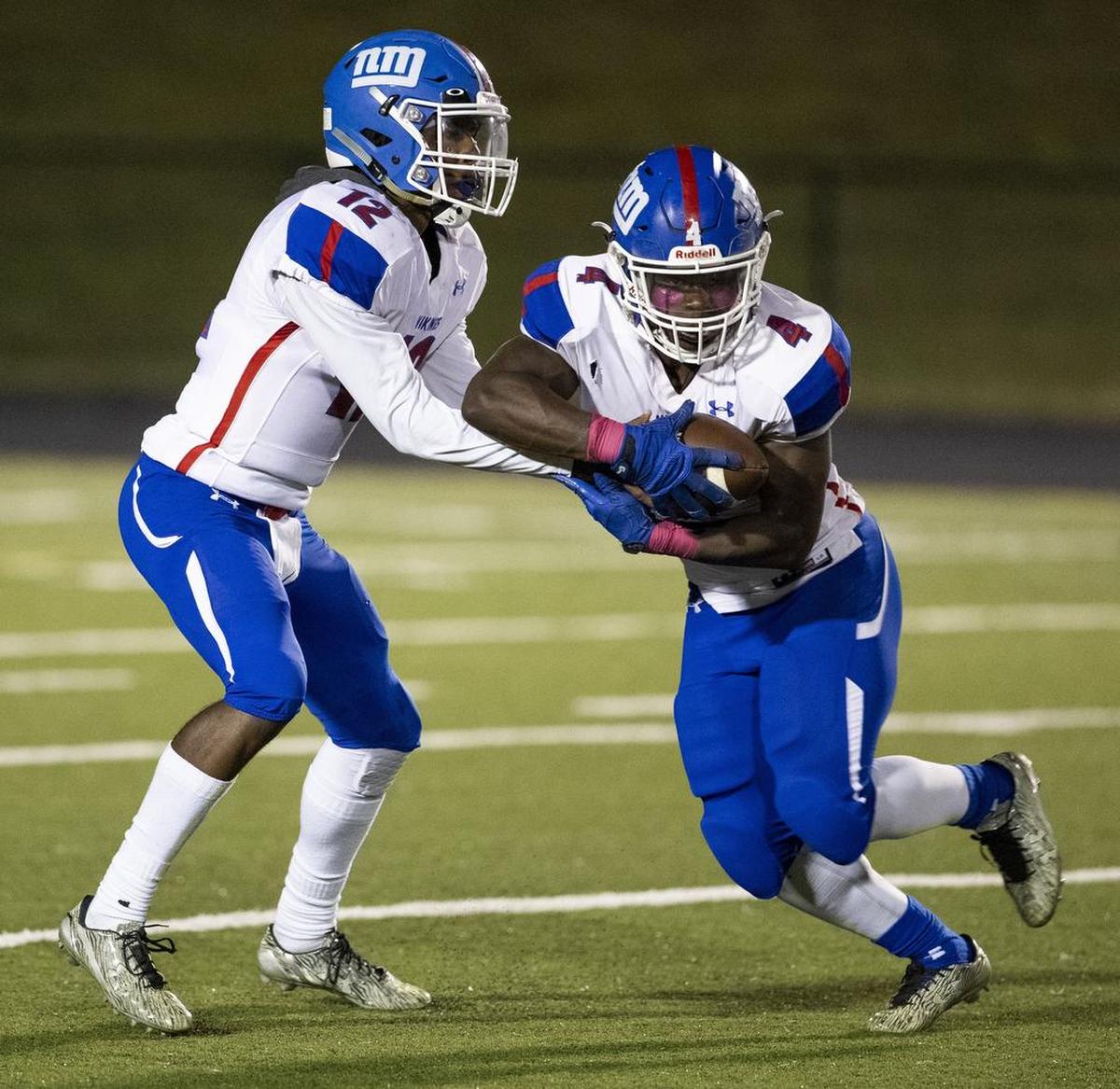 North Meck quarterback Aaron Scott hands off to Fabian Duncan on Friday night at Hough.