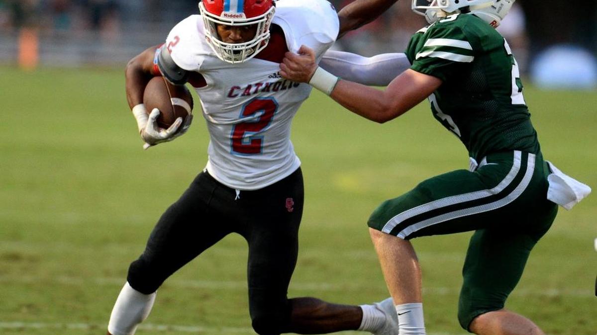 Charlotte Catholic's Howard Milan, left, fights for yardage on a run as Charlotte Country Day linebacker John Hosmer, right, attempts to make the tackle during first quarter action at Charlotte Country Day on Friday, September 1, 2017.