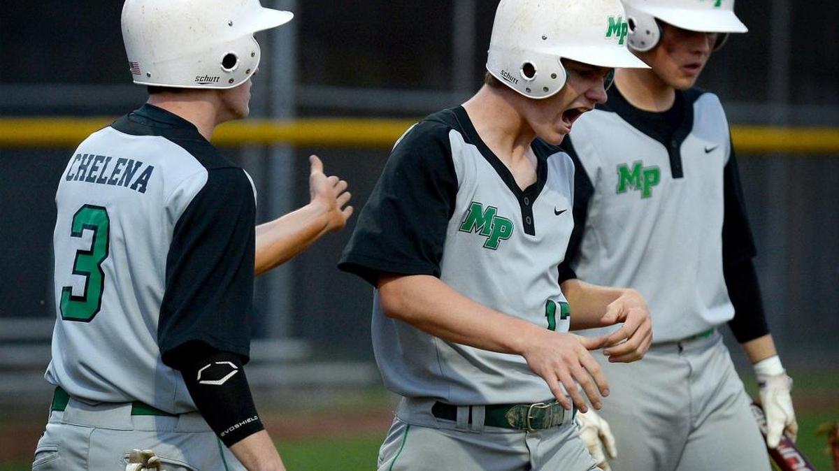 Myers Park’s Owen Capps (center) celebrates after scoring a run against East Mecklenburg in Tuesday’s baseball game at East Mecklenburg. He is congratulated by teammate Vince Chelena (left).