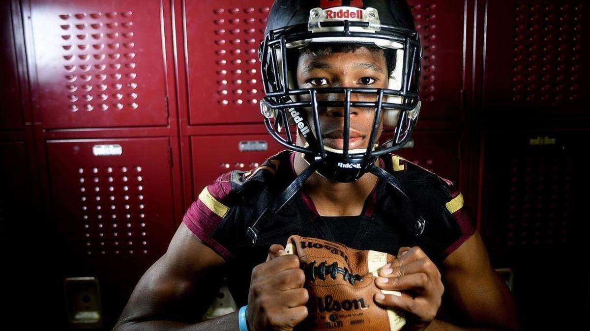 Harding freshman running back Quavaris Crouch squeezes a football in the Harding football locker room. Harding coach Sam Griner thinks he may have the best running back in Mecklenburg County history in 6-2, 200 pound Crouch, who is already being recruited by UNC and Clemson. "Some people are just made for the sport," Griner says of Crouch.