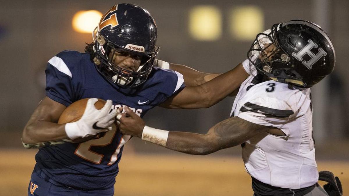 Vance running back Jahlik Cooper (21) pushes off Hough defender Jackson Kmieciak (3) during a 4AA high school football playoff game at Vance High on Friday. Vance won to advance to the West final.