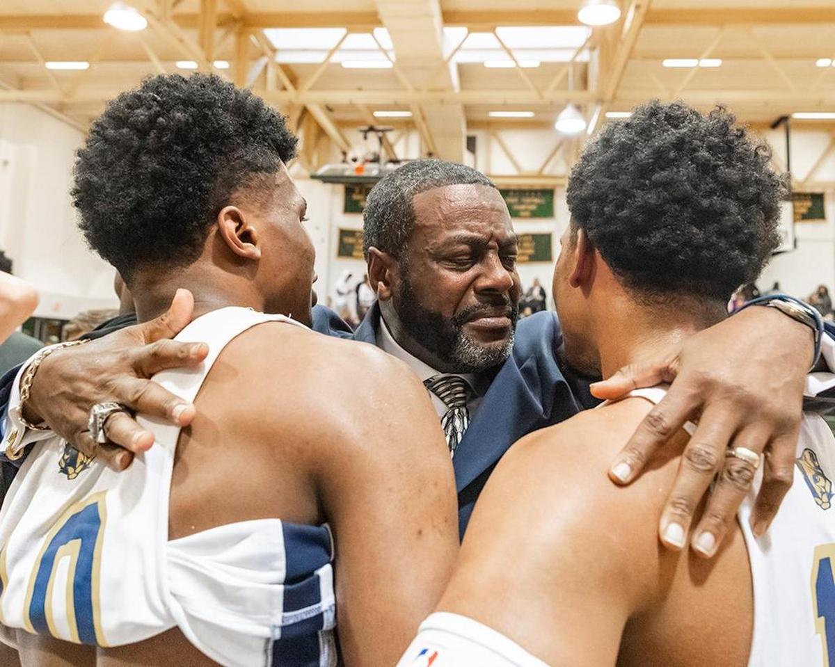 Carmel Christian Head Coach Joe Badgett embraces senior Captain’s Donovan Gregory (left) and Myles Pierre (right).