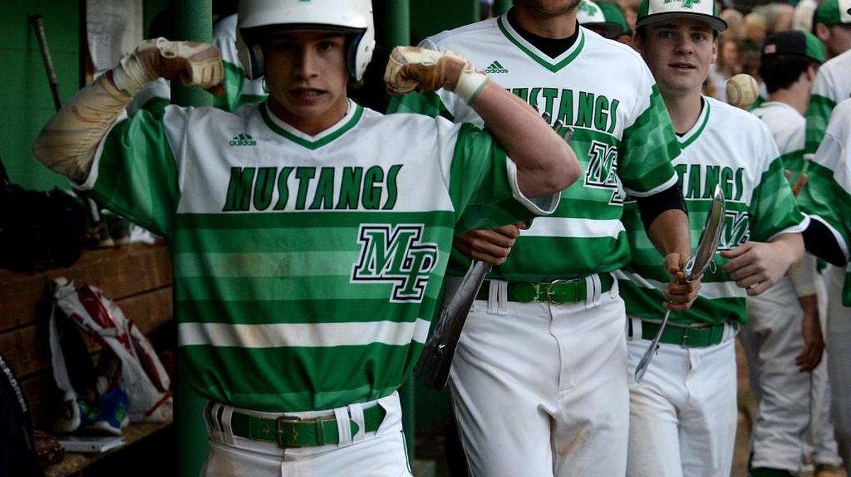 Myers Parks #15 Patrick Alvarez, left, raises his arms as he is congratulated by teammates after scoring a run during Friday's Butler at Myers Park matchup in a battle of teams tied for first place in the Southwestern 4A baseball standings.