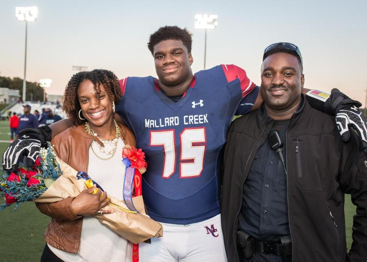 Mallard Creek defensive lineman Jordan Davis, seen here on senior night with his parents, committed to Georgia Thursday