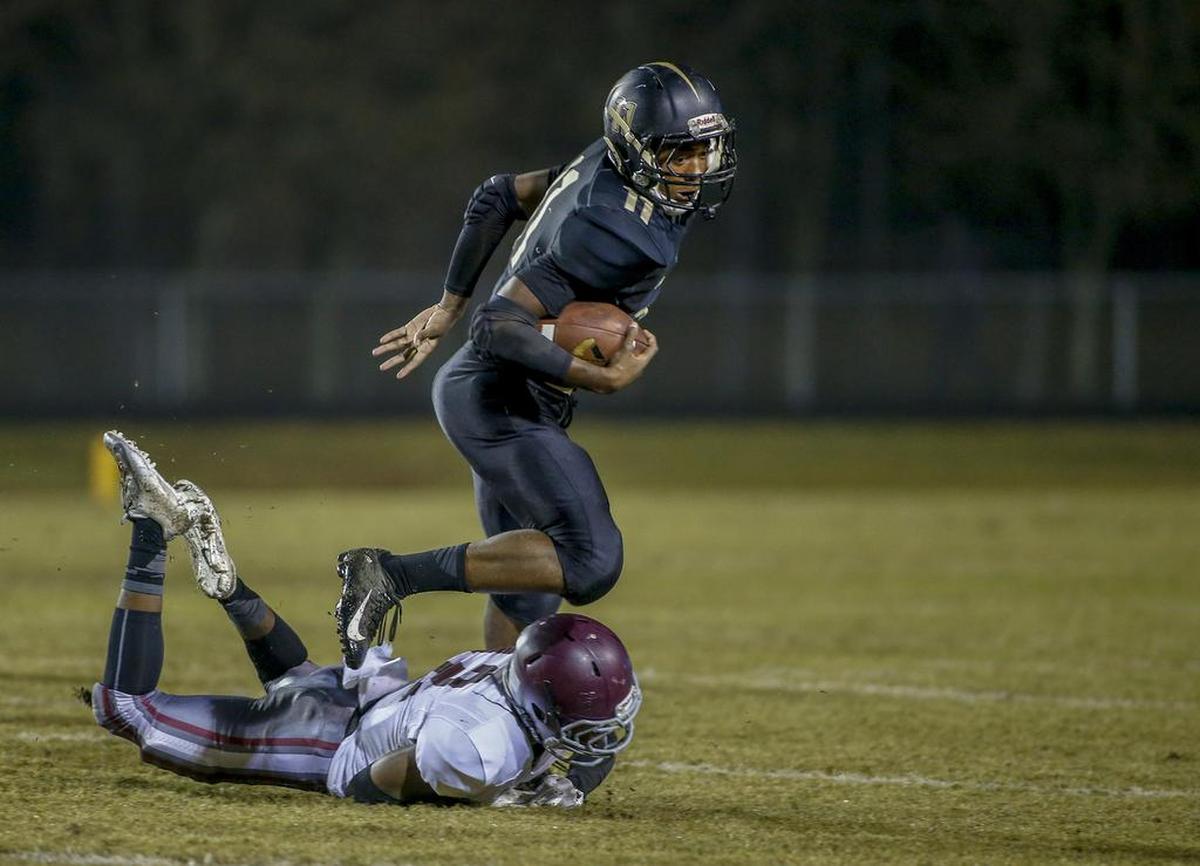 Providence running back Jamar Price (11) avoids West Mecklenburg cornerback Kynieu Wylie in the first quarter in high school football action Friday.
