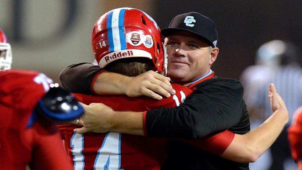 Charlotte Catholic quarterback John Walton is hugged by offensive line coach Frank Garcia following the team's victory over J.H. Rose in the NC 4A football championship game at BB&T Field in Winston-Salem, NC on Saturday, December 12, 2015. Catholic defeated J.H. Rose 27-20. Under a new NCHSAA proposal, Catholic would leave a conference of Charlotte schools for a Union County league..