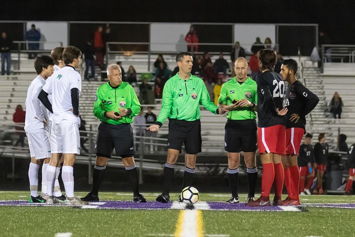 The Myers Park and South Meck captains prepare for the coin toss before Tuesday’s state semifinal. Myers Park won 2-1.