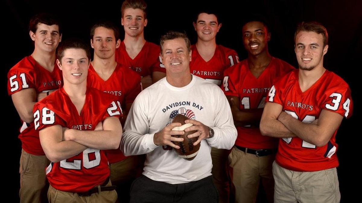 Former Davidson Day football coach Chad Grier, seen here with some of his former players, landed a new high school football job Tuesday.