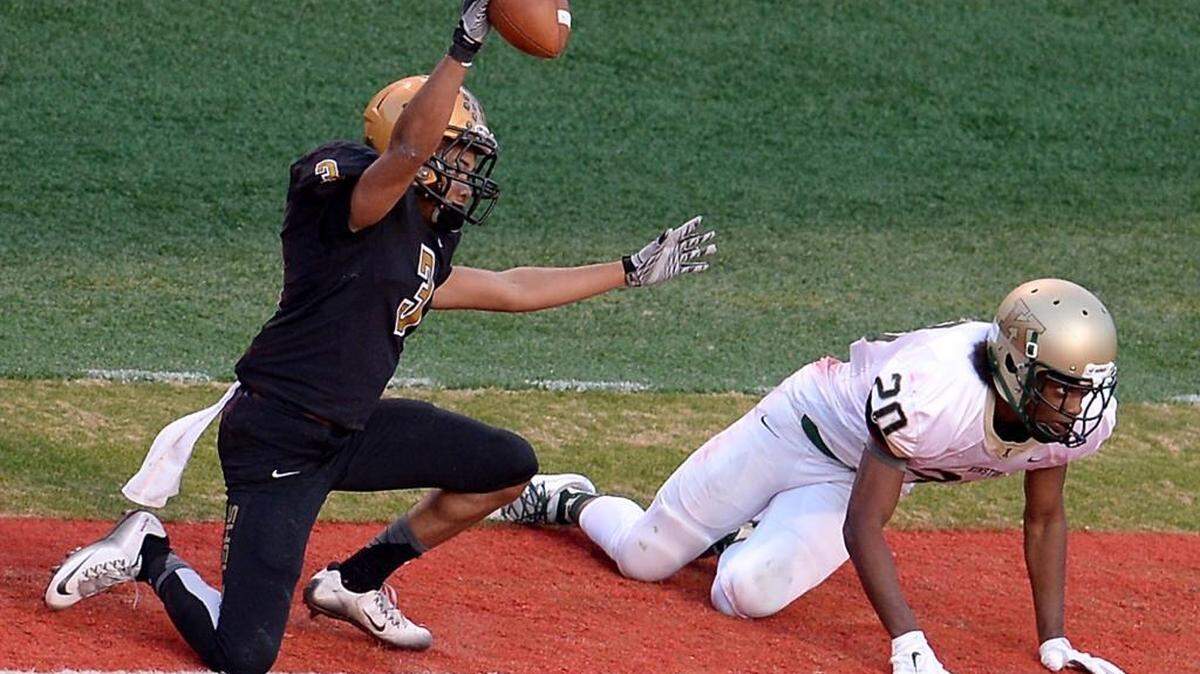 Shelby wide receiver Kavacia Shell, left, celebrates his touchdown reception against Kinston defensive back Daenard Branch in the first quarter of Saturday’s N.C. 2A championship in Raleigh. Shelby won 57-21.