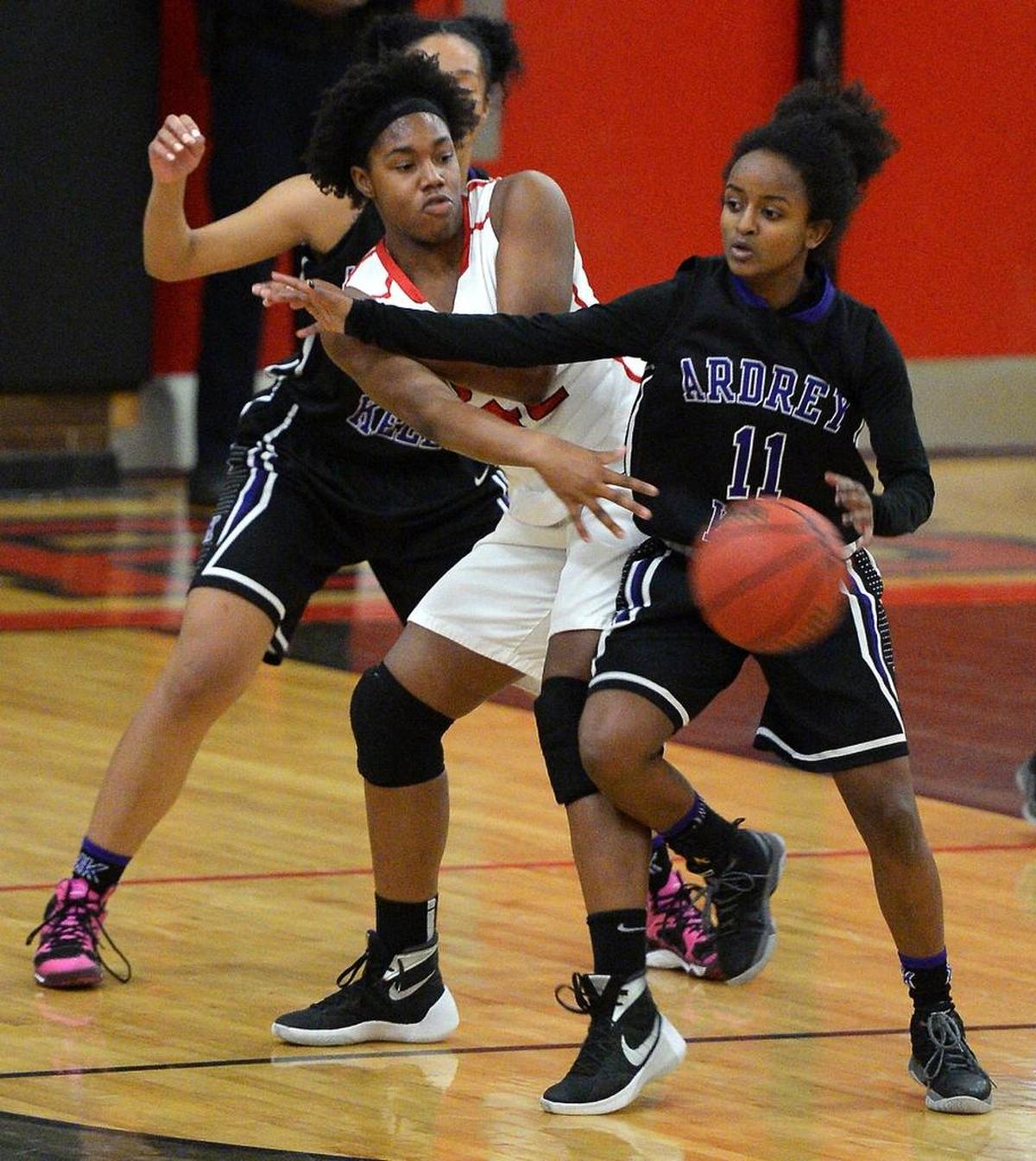 South Meck's A'lea Gilbert, center, passes a ball around Ardrey Kell's Journey Muhammad, right, and Krysta Davis, left, in game that South Meck won last season