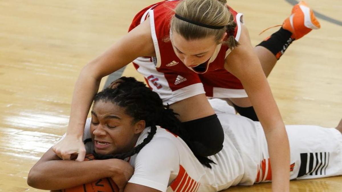 Rocky River's Kanijah Cooper, bottom, holds onto the basketball as Charlotte Catholic's Claire Kloiber dives across her during the second half of a high school basketball game at Rocky River in Mint Hill, N.C., Tuesday, Dec. 20, 2016. (Nell Redmond photo)