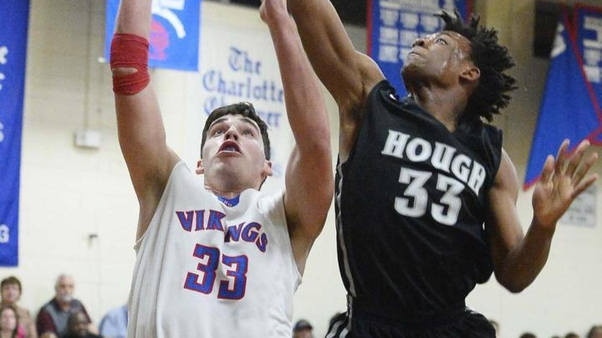 North Meck's Ethan Walker, left, shoots the ball against Hough's Damon Early during Tuesday night's game at North Meck.