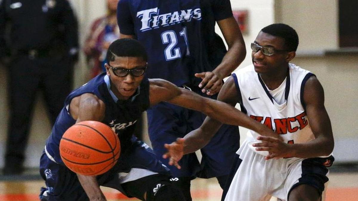 Hopewell guard Mark Sherrill, left, and Vance guard Marcus Neal battle for a loose ball as Hopewell forward Jeremiah Smalls looks on in a prep basketball game last season at Vance High School. (Nell Redmond photo)