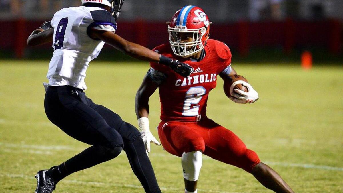 Charlotte Catholic running back Milan Howard, right, looks to cut back as Ardrey Kell’s Gabriel Jeudy tries to make the tackle Friday night. Howard rushed for 157 yards and scored two touchdowns in the Cougars’ 38-14 win.