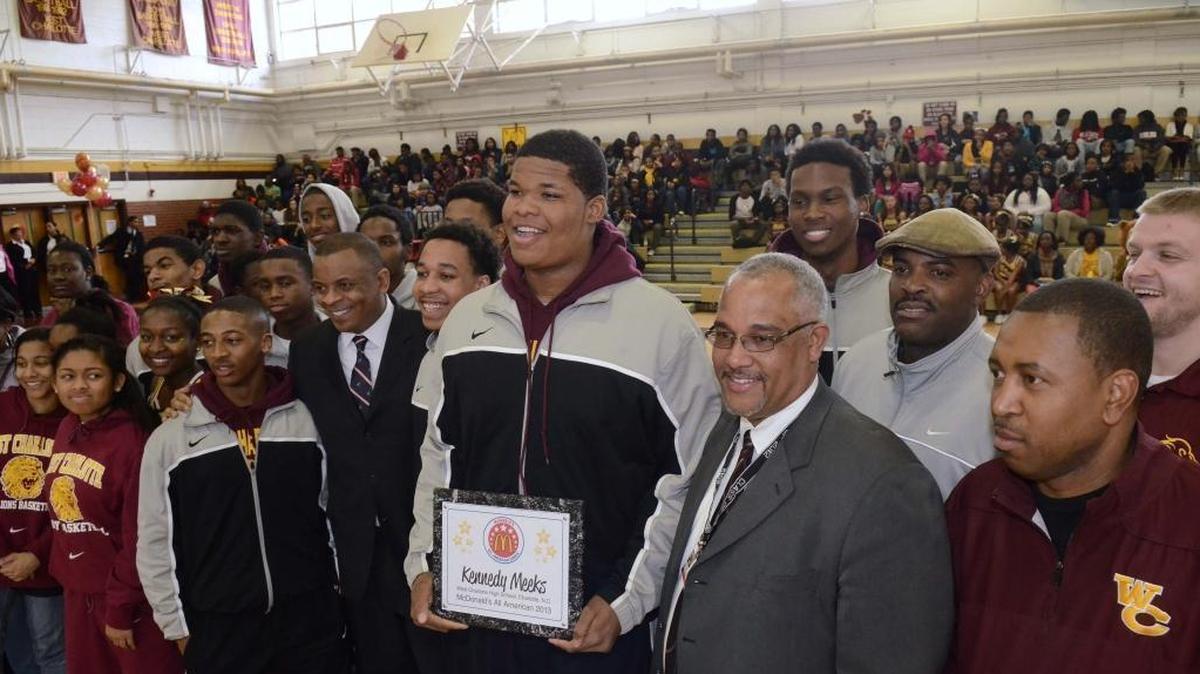In 2013, former Charlotte Mayor Anthony Foxx (left),West Charlotte high basketball player Kennedy Meeks (center), McDonald's owner/operator John Hairston (right)(gray suit) , a former West Charlotte grad, surrounded by teammates,students and coaching staff, Meeks was recognized for his achievement for being selected to play for McDonald's All-American Game