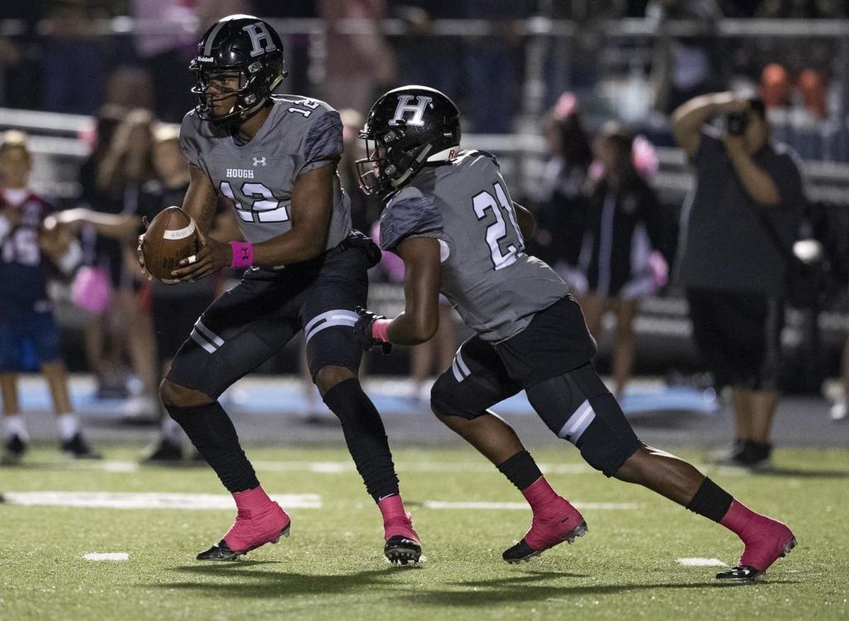 Hough High quarterback Kennique Bonner-Steward hands the ball to a teammate in Friday’s game against North Mecklenburg.
