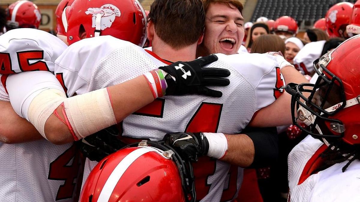 (L-R) South Point teammates defensive end Nolan Cochran, defensive tackle Payton Graham and tight end Hunter Cornelison were all smiles and hugs after winning the N.C. 2AA state title last December. On Tuesday, the Red Raiders moved to No. 1 in a statewide 2A media poll.
